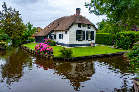 Giethoorn, Netherlands - July 6, 2019: Typical Dutch village house with traditional roof in the village of Giethoorn, the Netherlandsのeditorial素材
