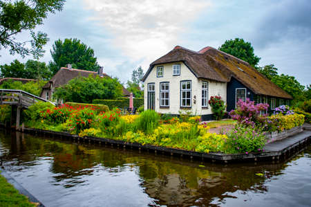 Giethoorn, Netherlands - July 6, 2019: A typical Dutch rural house with traditional grass roof in the village of Giethoorn, known as the Venice of Netherlandsのeditorial素材