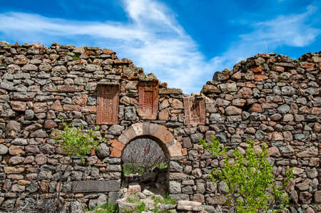 Ancient stone walls with built in Armenian khachkars (cross stone) at the Havuts Tar monastery complex in Armeniaの写真素材