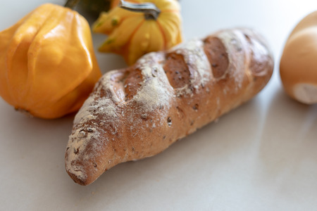 Bread and whole grain bread and autumn pumpkins on textured light backgroundの写真素材