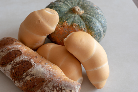 Bread and whole grain bread and autumn pumpkins on textured light backgroundの写真素材