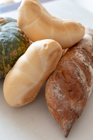 Bread and whole grain bread and autumn pumpkins on textured light backgroundの写真素材