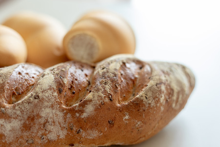 Bread and whole grain bread on textured light background
