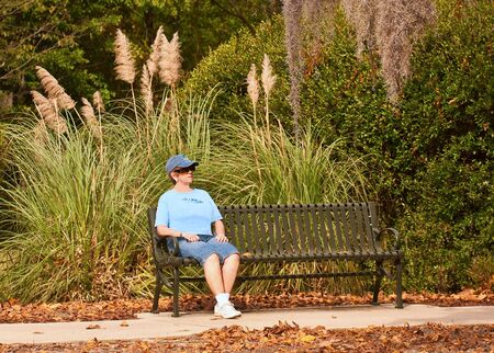 Woman hiker relaxing on a bench  の写真素材