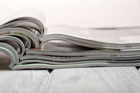 stack of magazines on a white-painted wooden table