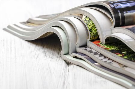stack of magazines on a white-painted wooden table