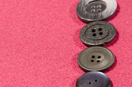 dark buttons on red textile cloth with space for inscription