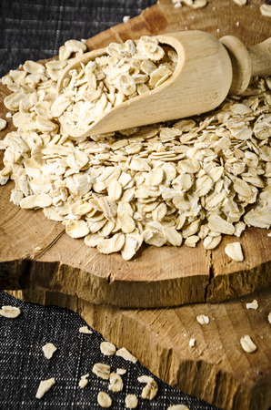 raw oatmeal scattered on the brown trencherの写真素材