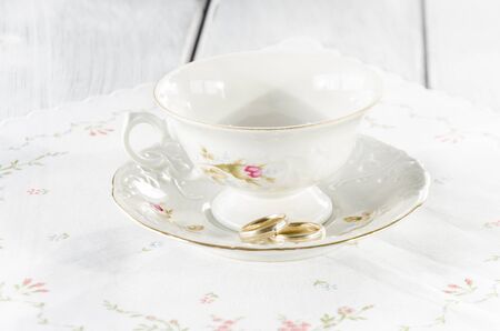 elegant old cup made of genuine porcelain with gold wedding ringの写真素材
