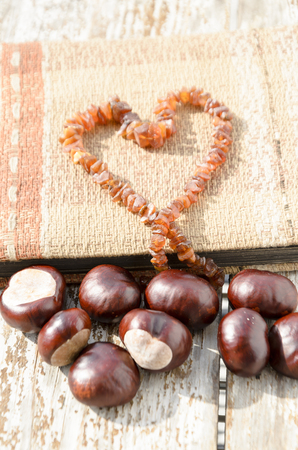 Old photo album with heart created from amber necklaceの写真素材