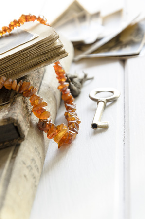 Stack of old photographs with amber necklace on photo albumの写真素材