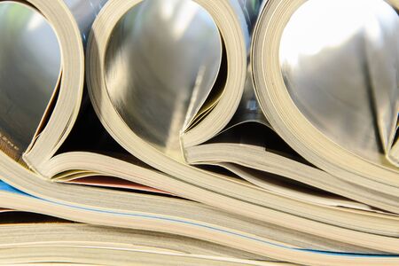 side view of a stack of magazines with glossy paper