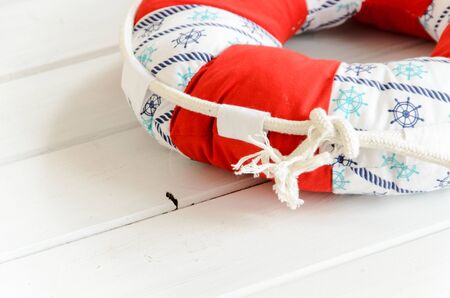 Lifebuoy handmade pillow on white wooden table with copyspace