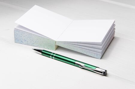 small notepad on white desk with pencil