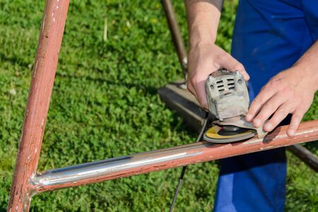 Angle grinder, metal structure renovation in a garden