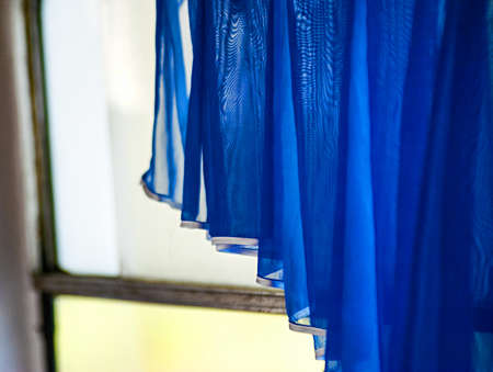 dark blue curtain in a bright windowの写真素材