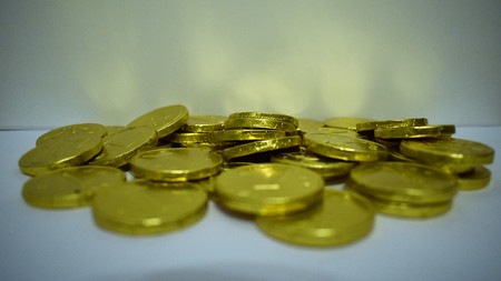 Gold chocolate coins on white backgroundの写真素材