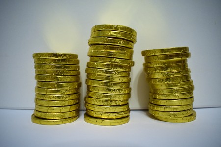 Gold chocolate coins on white background