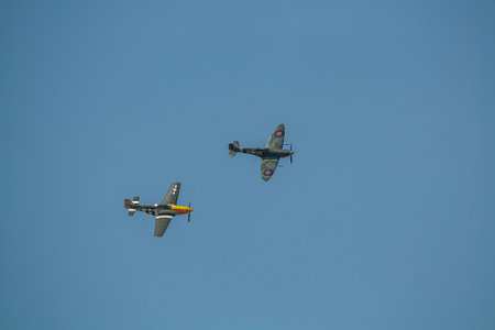 A Supermarine Spitfire and North American P-51 Mustang flying in tandemのeditorial素材