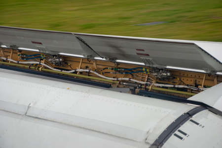 Air brakes and flaps on an aircraft wing as it slows after landing