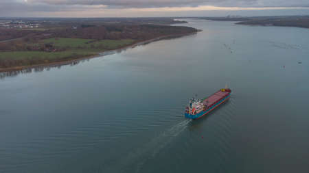A cargo ship sailing down the River Orwell in Suffolk, UKの写真素材