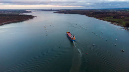 A cargo ship sailing down the River Orwell in Suffolk, UKの写真素材