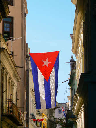 A Cuban flag hanging from a building in Old Havanaの写真素材