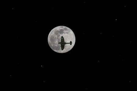 The silhouette of a Supermarine Spitfire Mk IIa against a full moonの写真素材