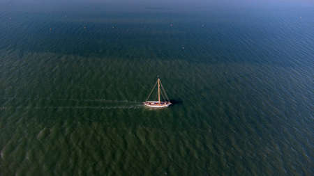 An aerial view of a lone boat on a river in Suffolk, UKの写真素材