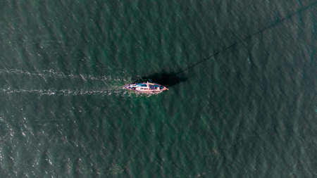 An aerial view of a lone boat on a river in Suffolk, UK