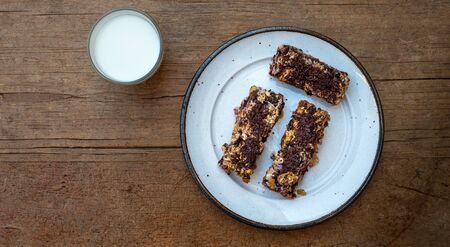 home made healthy cereal bars.in kitchen with glass of milk  honey pot ,& drizzler, Stuck at home.