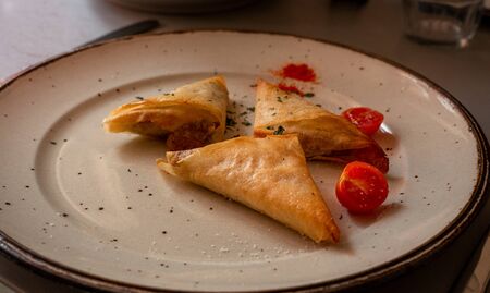 homemade samosas on on plate with small tomatoes, home cooking. stuck inside.