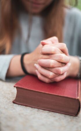 teenage girl praying , hands on bible. concept of faith & hope.の写真素材