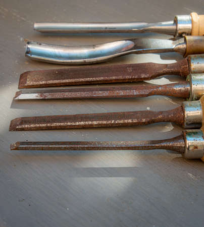 old wood working chisels on a gray painted table, hobby or pastime. diy at home