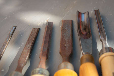 old wood working chisels on a gray painted table, hobby or pastime. diy at home