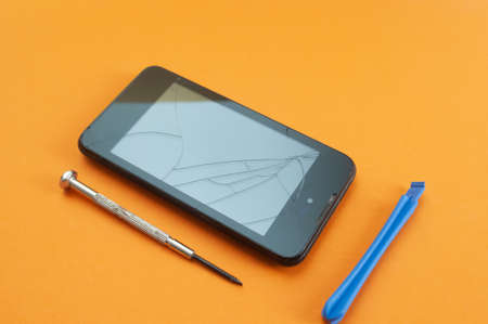 smart phone with broken screen and tools for repair. bright graphic image.の写真素材