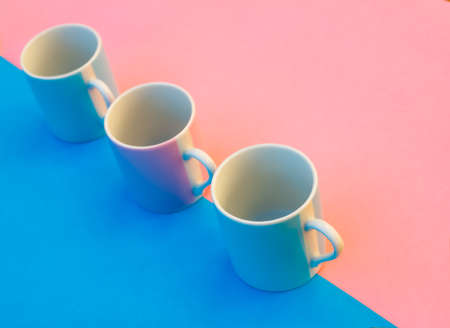 Pink and blue coffee cups on colored background, graphic image with bright colors.