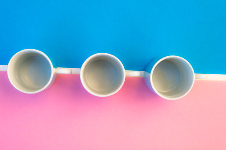 Pink and blue coffee cups on colored background, graphic image with bright colors.の写真素材