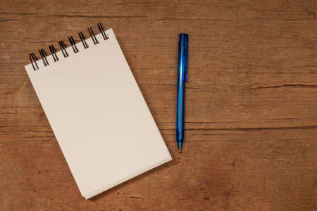 blank note book and pen on wooden table, mock up