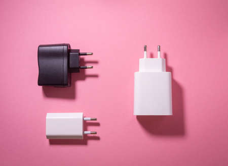 white and black usb charging blocks on a pink backgroundの写真素材