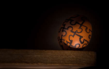 Egg with jigsaw design on the edge, concept risk, danger or fragility.の写真素材