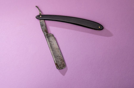 antique old cut throat or straight razor on a pink background.の写真素材