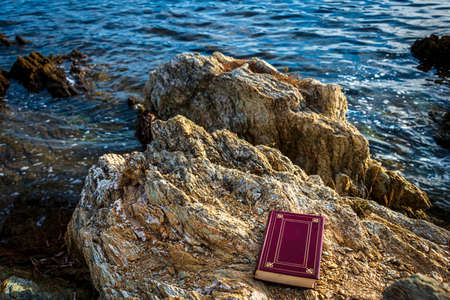 book on rocks next to the sea Concept of relaxing on holiday.の写真素材