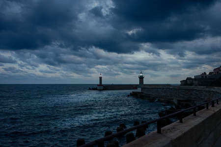 stormy entrance to Bastia port with lighthouse, Corsica, France.