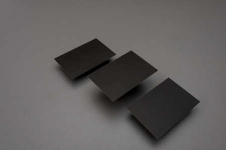 Black mock up business card for branding on gray rustic background.