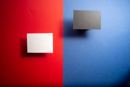 black and white mock up business cards on a blue and red background.の写真素材