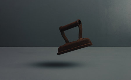 old rusty iron or flat iron floating on gray blue background.の写真素材