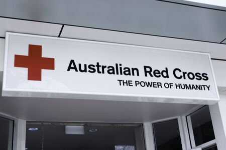 Gold Coast QLD Australia, May 24 2019: Australian red cross sign. White with black writing and a picture of a red cross. The words the power of humanityのeditorial素材