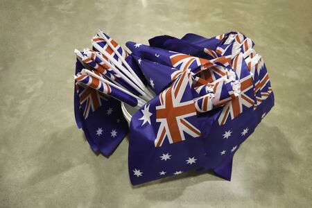 Lots of little Australian flags in a bucket. The flag with the southern cross, union jack on a blue...