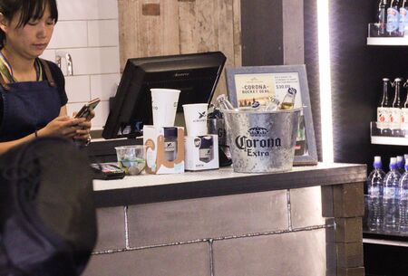 Queenstown, New Zealand 30 January 2020: Asian woman at till and corona beer in bucketのeditorial素材